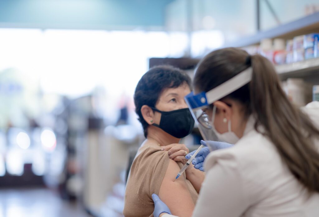 Senior Woman Getting the COVID-19 Vaccine Injection Stock Photo A senior woman of Asian descent is receiving her COVID-19 vaccine injection at the pharmacy.